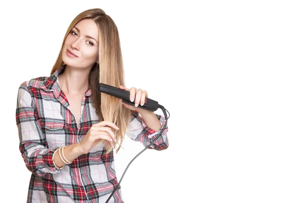 Женщина с помощью выпрямителя для волос — стоковое фото