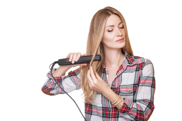 Женщина с помощью выпрямителя для волос — стоковое фото