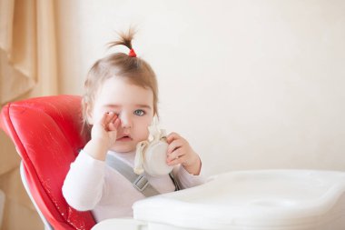 Kırmızı sandalyesi oturan bebek kız