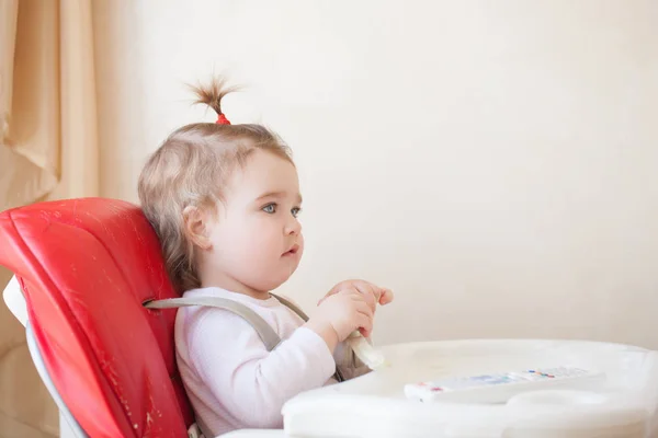 Kırmızı sandalyesi oturan bebek kız