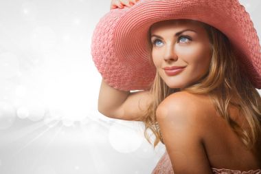 Pembe elbise ve şapka oturan kadın