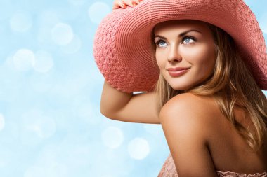 Pembe elbise ve şapka oturan kadın