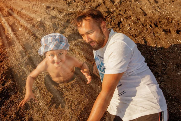 Fadern spelar med son handpåläggning beach — Stockfoto