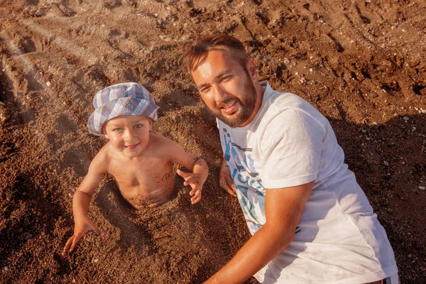 Fadern spelar med son handpåläggning beach — Stockfoto