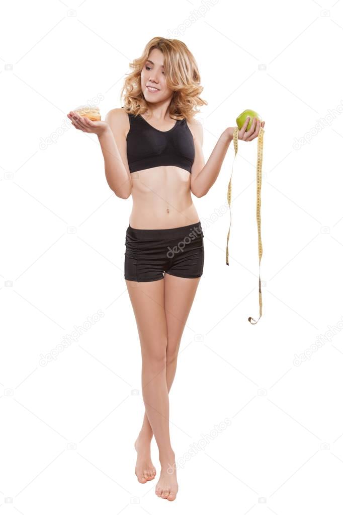 Woman weighting apple and tape measure and cake