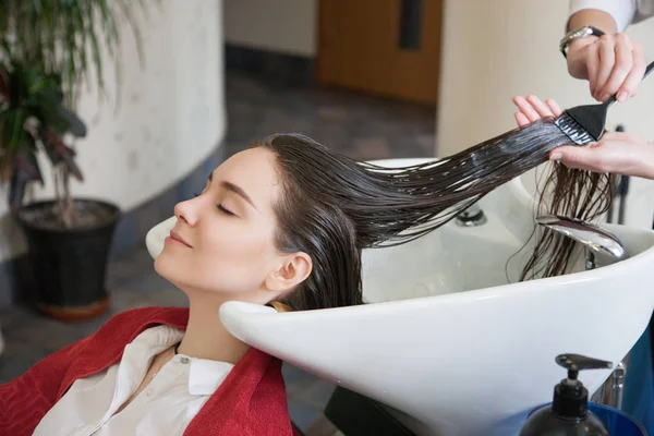 Hairdresser dyeing hair for customer