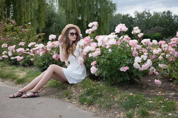 花の前に芝生の上に座っている女性 — ストック写真