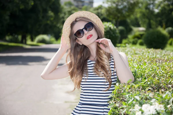 Kadın ayakta hasır şapka ve çizgili elbise