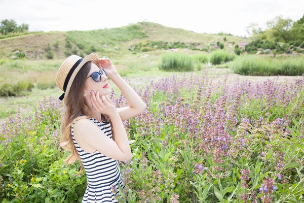 Mujer de pie en sombrero y vestido en el campo — Foto de Stock