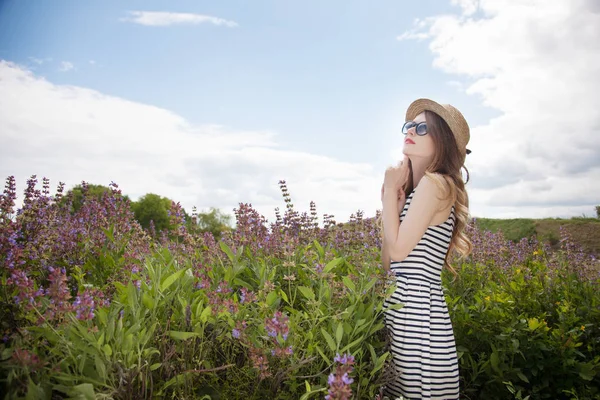 Mujer de pie en sombrero y vestido en el campo — Foto de Stock