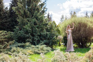 Çalılar ve Ladin arasında duran kadın