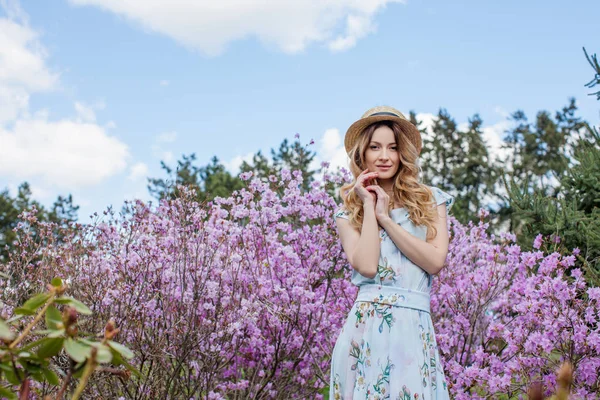 Woman standing in front of violet flowers — Stock Photo, Image