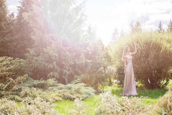 Женщина, стоящая между кустами и деревьями — стоковое фото