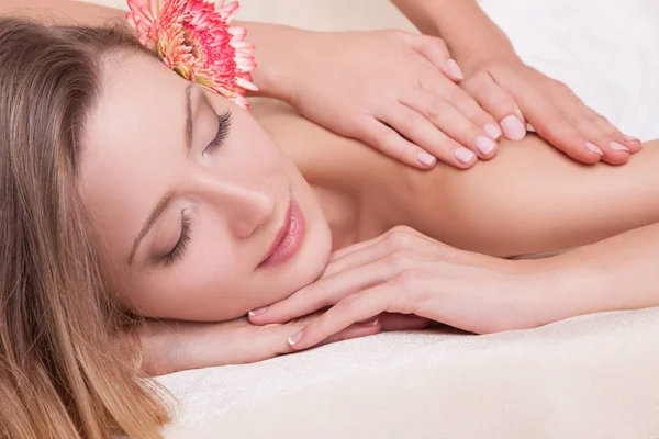 Kvinna ligga på massagebänk med blomma — Stockfoto