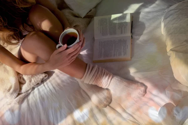 Mujer sentada y sosteniendo una taza de té — Foto de Stock