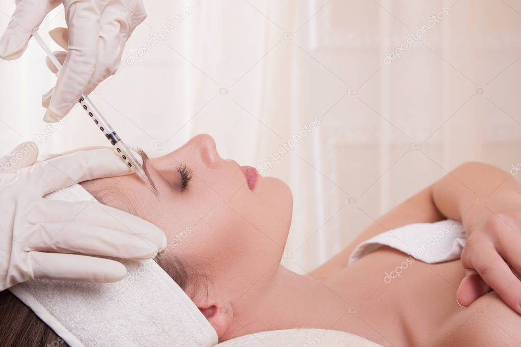 Woman getting injection in eyebrow