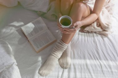 Oturma ve çay tutan kadın