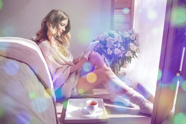 Katta oturan ve tablet okuma kadın