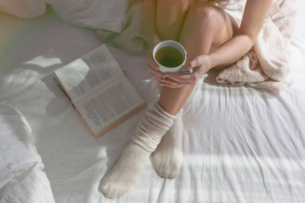 Oturma ve çay tutan kadın