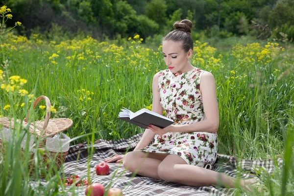Kvinna läser en bok på picknick — Stockfoto