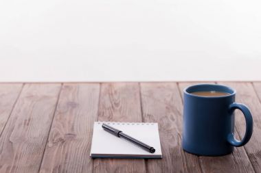 Defter ile kalem ve kahve masada