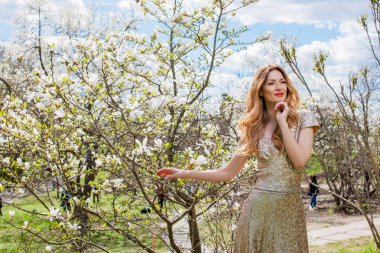 Güzellik sarışın genç kadın pembe elbise sicilini yaz Park çiçek açması ağacının altında