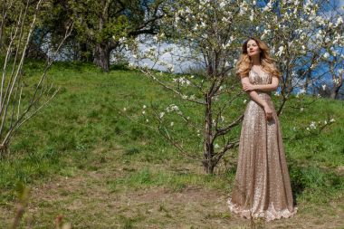 Güzellik sarışın genç kadın pembe elbise sicilini yaz Park çiçek açması ağacının altında