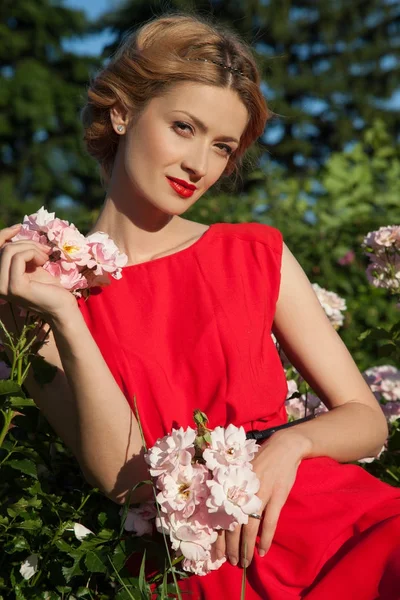 Szépség Fiatal Elegáns Sminket Visel Piros Ruhát Állva Portréja Virágok — Stock Fotó
