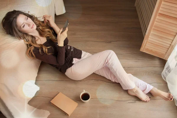 Pijama Giymiş Smartphone Yerde Duran Hoş Kokulu Kahve Fincanı Kullanarak — Stok fotoğraf