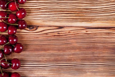 Tatlı Olgun Kiraz ahşap masa arka plan üzerinde yığını