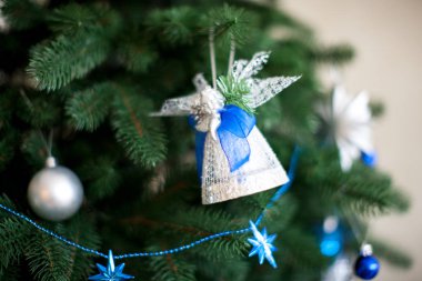 Ağaç dalları üzerinde dekore edilmiş Noel ağacı, garland, top ve melek oyuncak closeup astı