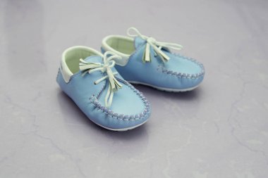 Portre studio arka plan üzerinde sevimli mavi çocuk ayakkabı