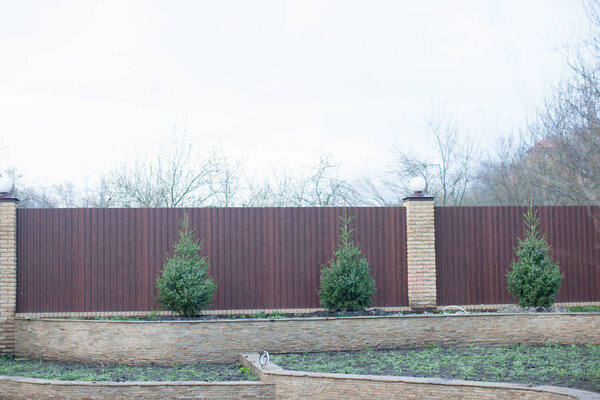 Посадка деревьев в почве, планирование участка, ландшафт. Коричневый металл
