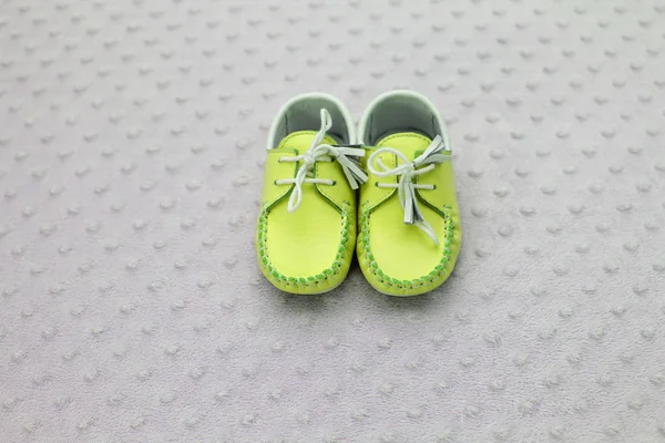 スタジオの背景にかわいいグリーン子供靴のクローズ アップ — ストック写真