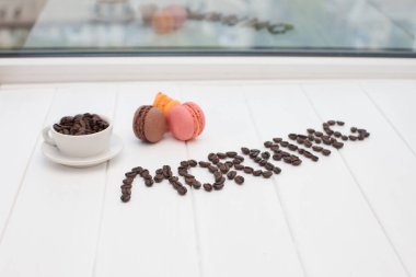 Sabah kahve kavramı. Beyaz ahşap masa arka plan üzerinde kızarmış kahve çekirdekleri Word kahve yapılmış.