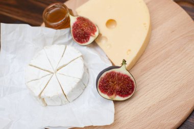 Dilimlenmiş peynir ve ahşap masa üzerinde incir çeşitleri closeup. Gıda arka plan, lezzetli yemek seti 