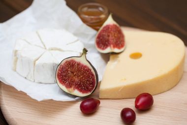 Dilimlenmiş peynir ve ahşap masa üzerinde incir çeşitleri closeup. Gıda arka plan, lezzetli yemek seti 