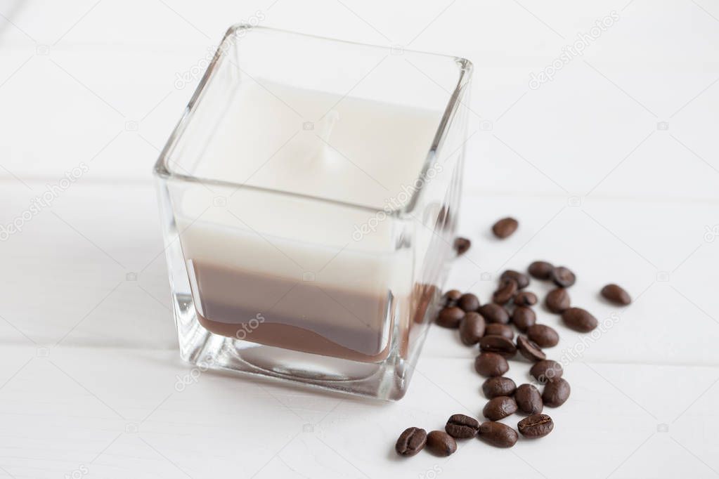 Closeup of cup of coffee with fried coffee beans on white background
