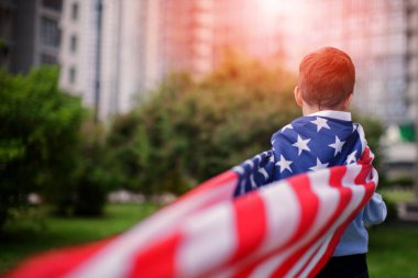 Genç Amerikan bayrağı, 4 Temmuz Yaz Park açık havada tutan çocuk. Vatansever tatil. Mutlu çocuk, Amerikan bayrağı ile küçük çocuk yakışıklı. 4 Temmuz Kutlamaları ABD