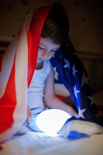 爱国假期 快乐的孩子 可爱的小男孩坐在美国国旗下用手电筒 美国庆祝7月4日概念 — 图库照片