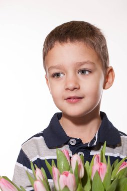 Stüdyo tatlı küçük çocuk kareli gömlek Pembe Lale elinde pembe kurdele ile bağlı buket beyaz stüdyo zemin üzerine ayakta vurdu 