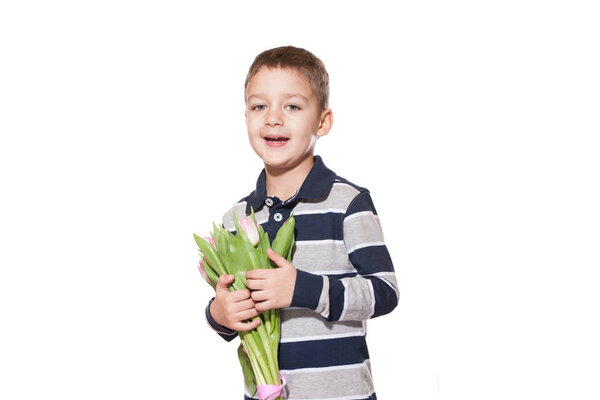 Studio shot of cute little boy wearing checkered shirt standing on white studio background with bouquet of pink tulips tied with pink ribbon in hands 