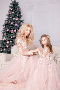 Anne ve kızı Noel hediyeleri tutan pembe etek giydiğini. Anne ve kızı Noel ağacı evde yakınındaki