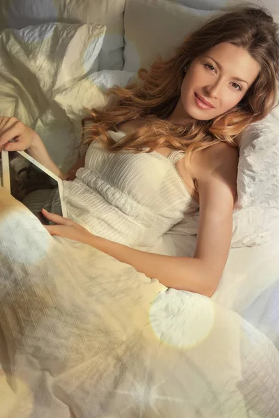 Yatakta Yatarken Dijital Tablet Kullanma Beyaz Elbise Giyen Güzel Genç — Stok fotoğraf