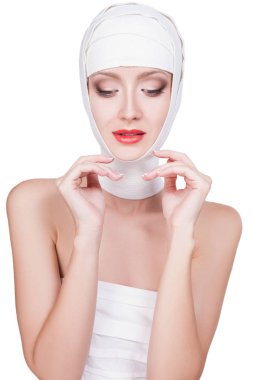 Başında, güzel yüz makyaj ile bandaj ile güzel genç kadın. Güzel kadın yüzüne kırmızı ruj beyaz arka plan üzerinde izole dudaklarında bandaj portresi