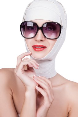 Kafa ile genç kadın portresi beyaz zemin üzerine güneş gözlüklü kız sargılı. Yüzündeki kırmızı ruj ile ince kadın. Anti-Aging tedaviler.