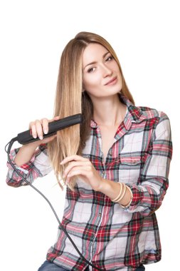 Stüdyo çekim saç düzleştirme kareli gömlek giymiş güzel genç kadın, beyaz stüdyo arka plan üzerinde izole