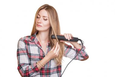 Stüdyo çekim saç düzleştirme kareli gömlek giymiş güzel genç kadın, beyaz stüdyo arka plan üzerinde izole