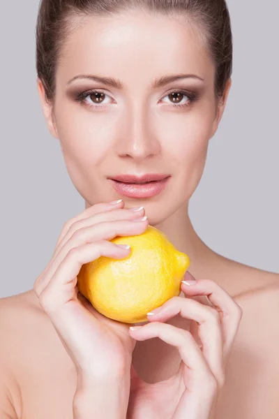 Studio Portrait Playful Young Woman Gathered Hair Lemon Hands Grey — Stock Photo, Image