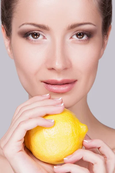 Studio Portrait Playful Young Woman Gathered Hair Lemon Hands Grey — Stock Photo, Image